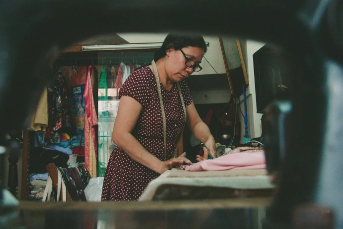 a woman standing in front of a sewing machine